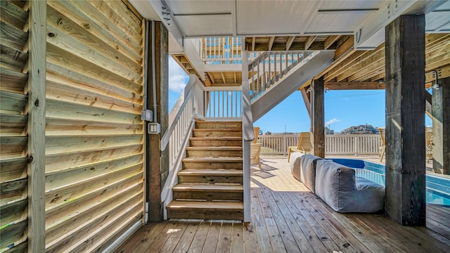 staircase with wood walls and wood finished floors