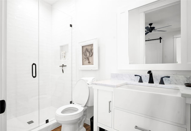 bathroom with a shower with shower door, toilet, vanity, and ceiling fan