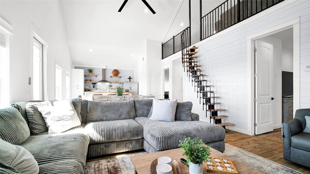 living room featuring ceiling fan, high vaulted ceiling, and wood-type flooring