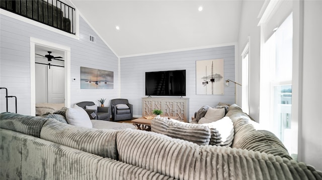 living room with ceiling fan, high vaulted ceiling, and wooden walls