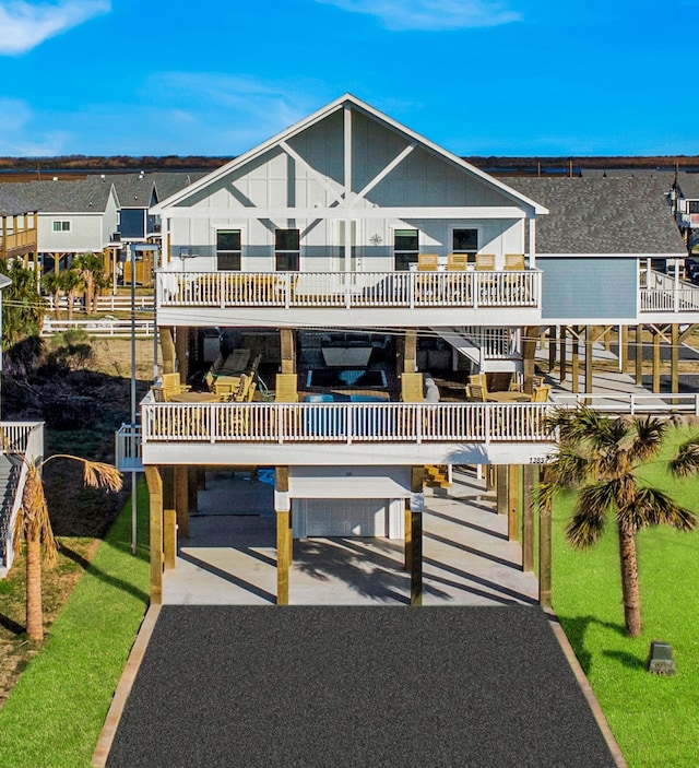 coastal inspired home with gravel driveway, a balcony, and a residential view