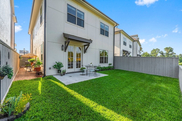 back of property with a patio area and a yard