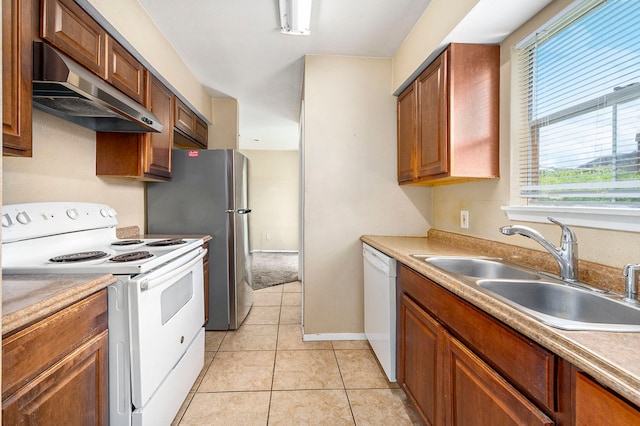 kitchen with light tile patterned floors, white appliances, and sink