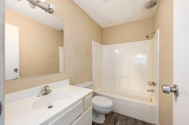 full bathroom with a textured ceiling,  shower combination, hardwood / wood-style floors, toilet, and vanity