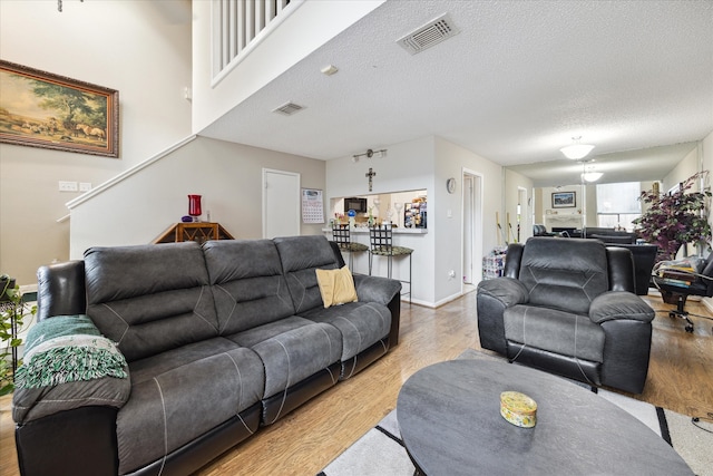 living room with a textured ceiling and light hardwood / wood-style floors