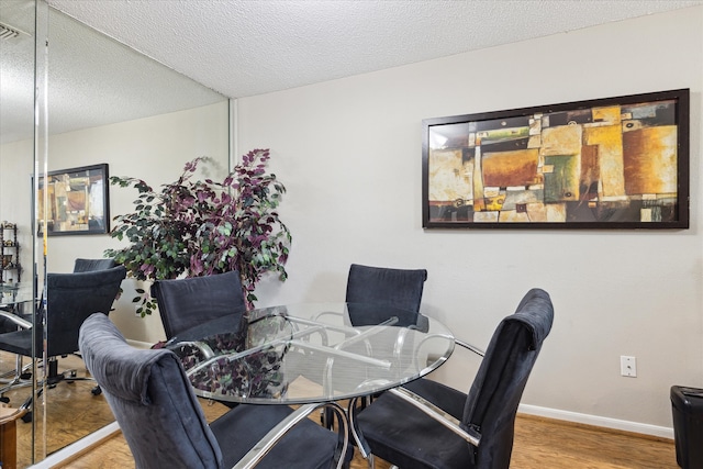 dining area with a textured ceiling and hardwood / wood-style flooring