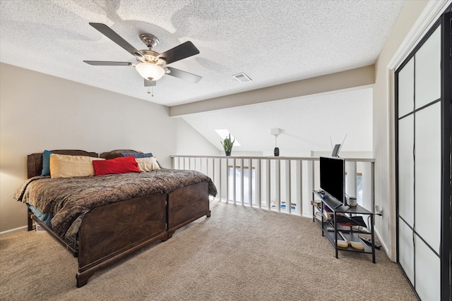 bedroom with lofted ceiling, a textured ceiling, carpet, ceiling fan, and a closet