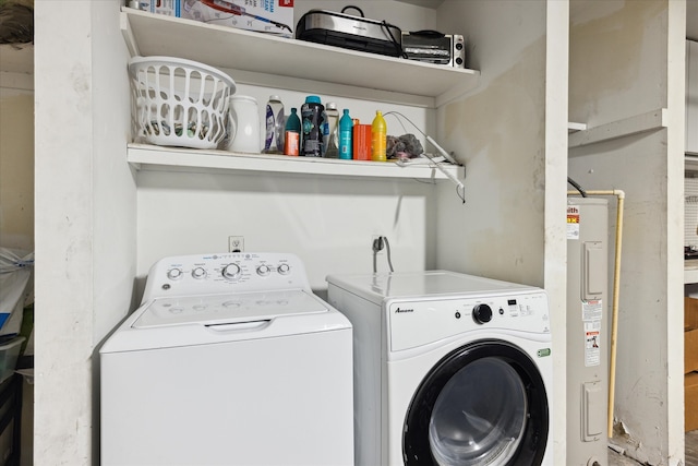 washroom featuring electric water heater and independent washer and dryer