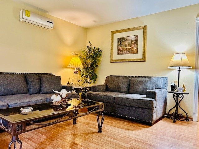 living room featuring wood-type flooring and a wall unit AC