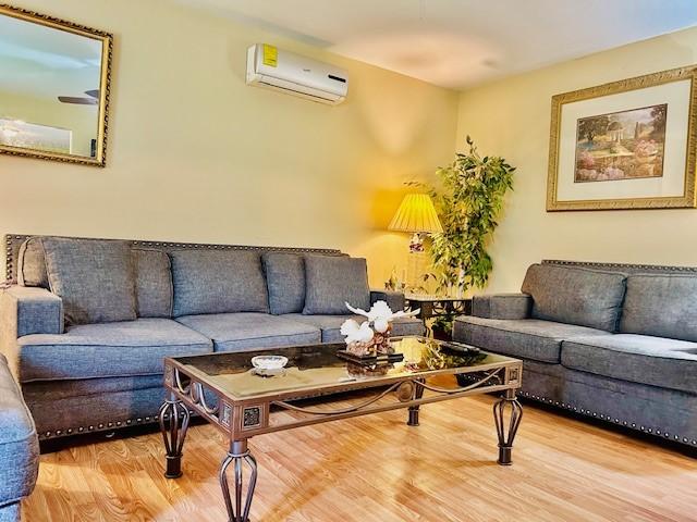 30470 Reids Prairie Rd, Waller, TX 77484 - living area featuring a wall mounted air conditioner and wood finished floors