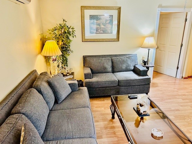 living room with light hardwood / wood-style floors and an AC wall unit