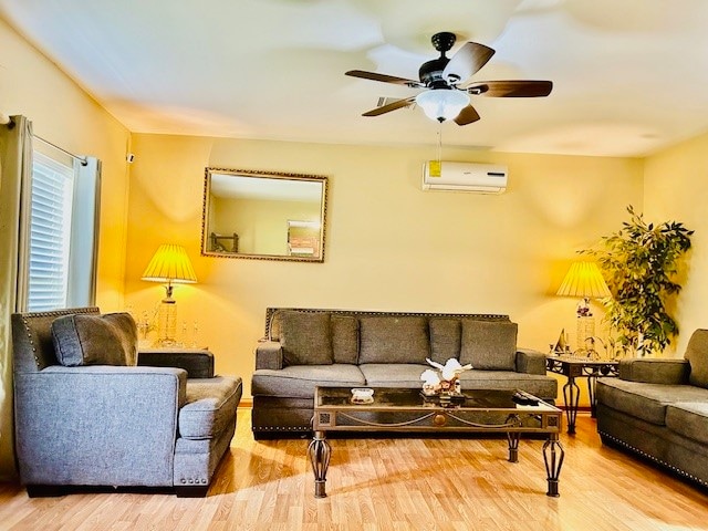 living room featuring ceiling fan, an AC wall unit, and light hardwood / wood-style flooring