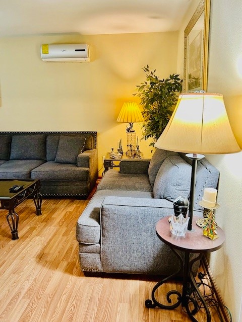 living room with hardwood / wood-style flooring and an AC wall unit