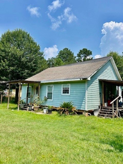 rear view of property featuring a yard