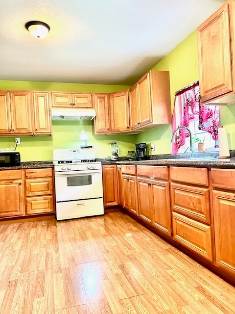 kitchen featuring sink, white range with gas stovetop, and light hardwood / wood-style floors