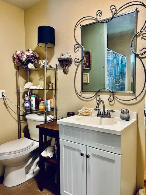 bathroom with tile patterned flooring, toilet, and vanity