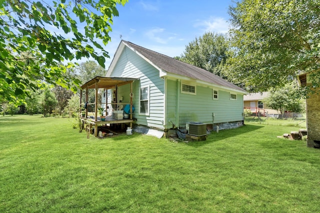 exterior space with central AC and a yard