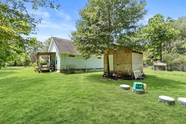 rear view of house featuring a lawn, a storage unit, and central AC unit