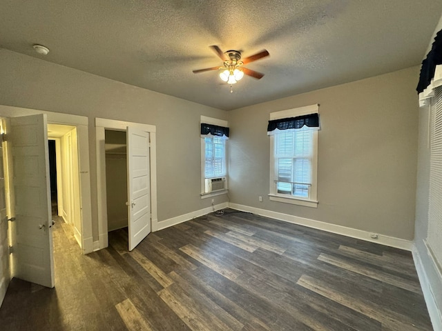 unfurnished bedroom with ceiling fan, a textured ceiling, dark hardwood / wood-style flooring, and cooling unit