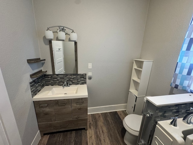 bathroom with backsplash, vanity, hardwood / wood-style floors, and toilet