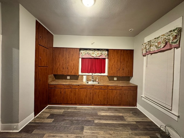 kitchen featuring dark hardwood / wood-style floors, sink, and a textured ceiling