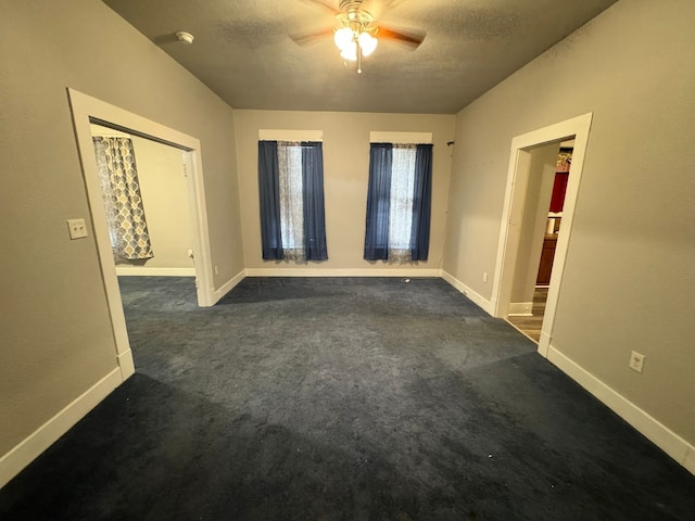 carpeted empty room with ceiling fan and a textured ceiling