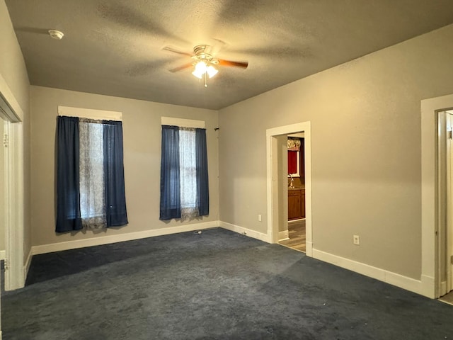 spare room with a textured ceiling, carpet flooring, and ceiling fan