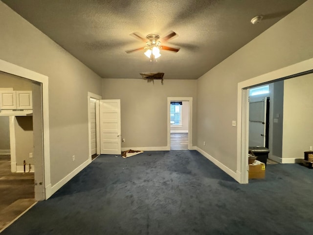 unfurnished bedroom featuring carpet, a textured ceiling, and ceiling fan