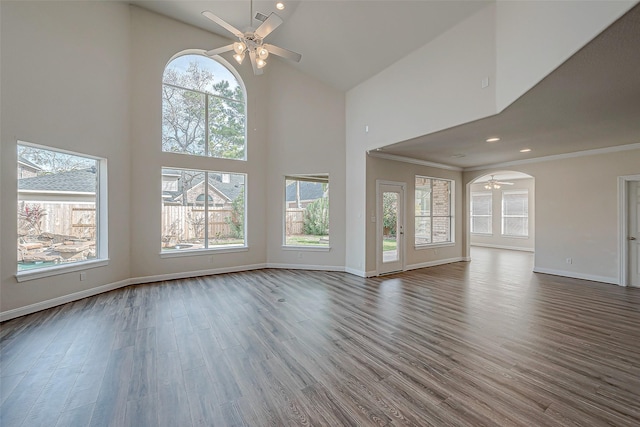 unfurnished living room with ceiling fan, hardwood / wood-style flooring, crown molding, and high vaulted ceiling