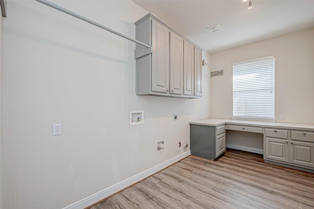 laundry room featuring hookup for an electric dryer, hookup for a washing machine, cabinets, light hardwood / wood-style flooring, and gas dryer hookup