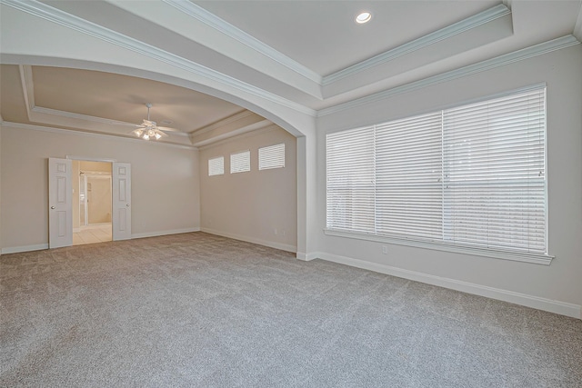 spare room featuring ceiling fan, light colored carpet, crown molding, and a tray ceiling