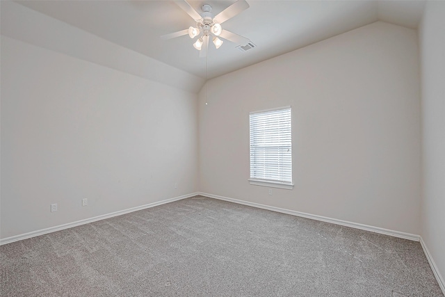 carpeted spare room featuring vaulted ceiling and ceiling fan