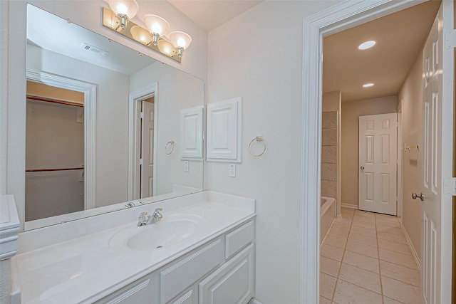 bathroom featuring plus walk in shower, vanity, and tile patterned flooring