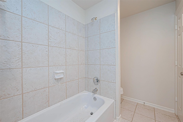 bathroom with toilet, tiled shower / bath, and tile patterned flooring