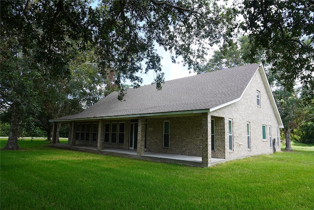 rear view of house featuring a yard and a patio