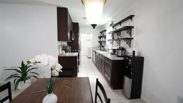 kitchen with sink, dark brown cabinetry, and light tile patterned floors