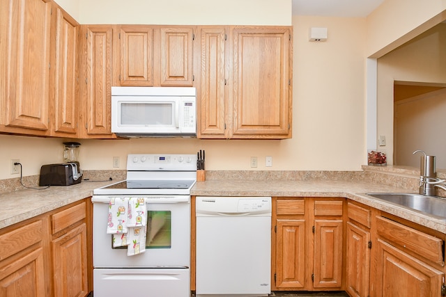 kitchen featuring light brown cabinets, white appliances, and sink