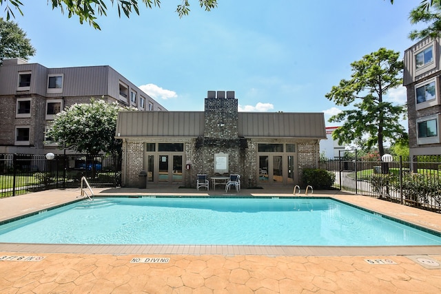 view of swimming pool with french doors and a patio area