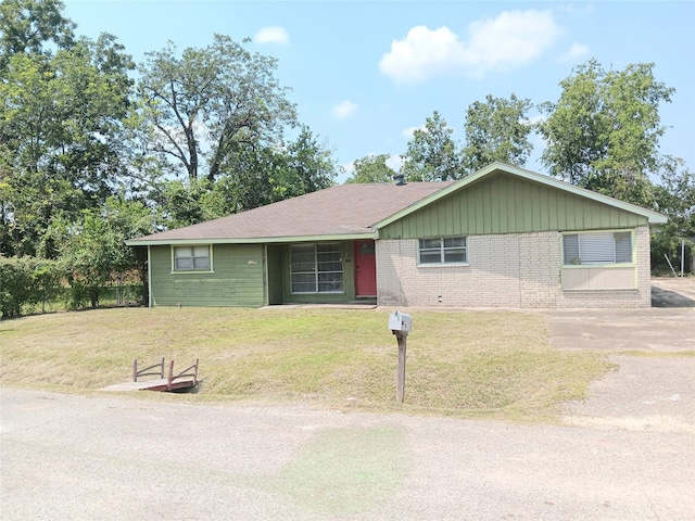 ranch-style home featuring a front lawn and brick siding