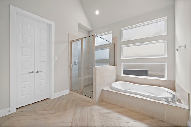 bathroom featuring parquet floors, plus walk in shower, and vaulted ceiling