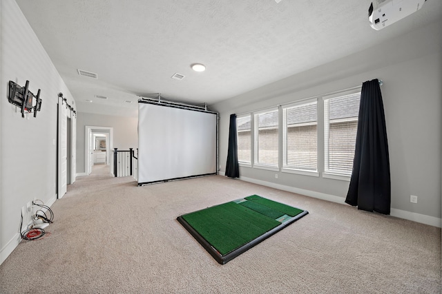 interior space with golf simulator, a barn door, light colored carpet, and a textured ceiling