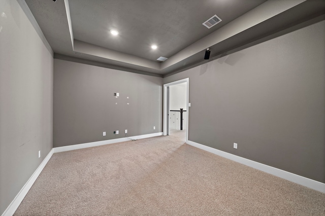 carpeted spare room with a tray ceiling