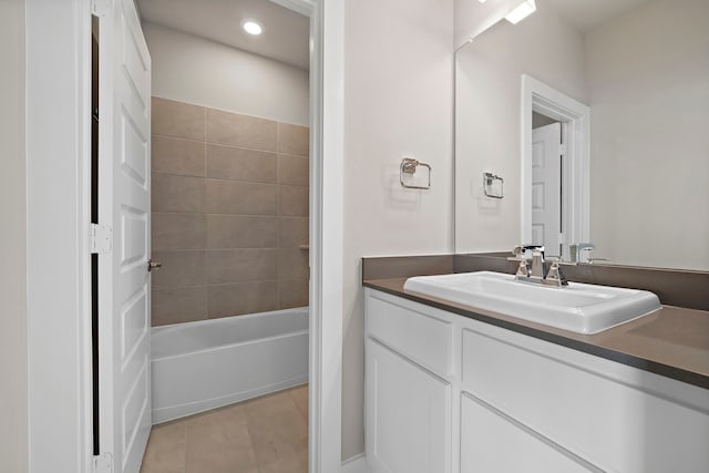 bathroom featuring tile patterned flooring, vanity, and tiled shower / bath