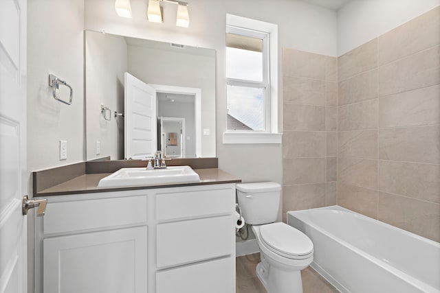 full bathroom with vanity, tiled shower / bath, hardwood / wood-style flooring, and toilet