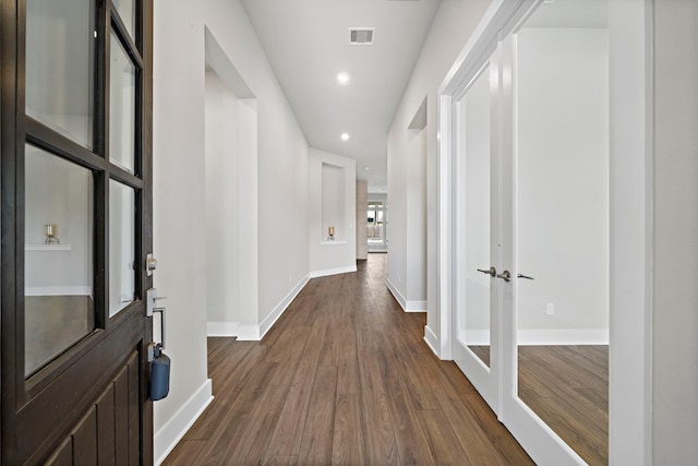 corridor featuring dark hardwood / wood-style flooring and french doors