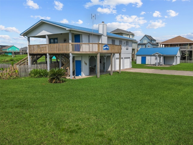 back of house with a deck, a lawn, and a garage