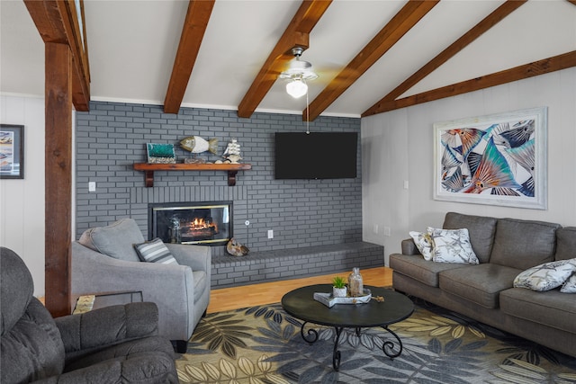 living room with hardwood / wood-style floors, a brick fireplace, brick wall, and vaulted ceiling with beams