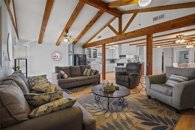 living room featuring lofted ceiling with beams, ceiling fan, and light hardwood / wood-style floors