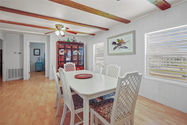 dining space with beam ceiling, ceiling fan, and light wood-type flooring