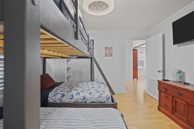 bedroom featuring light wood-type flooring and ornamental molding